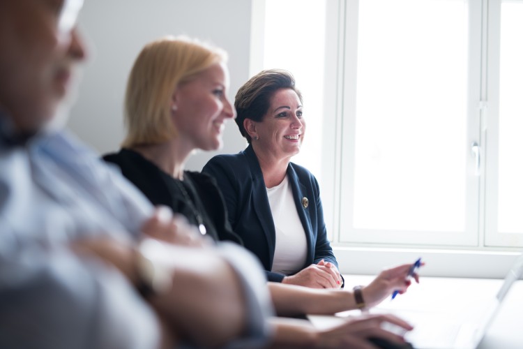 To mennesker som smiler mens de hører på noen prate
